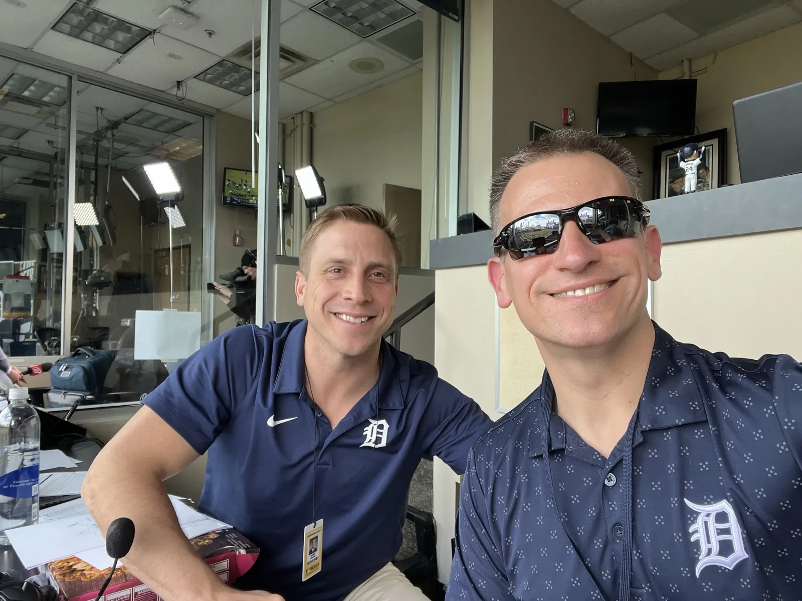 Greg Gania and a colleague in Tigers polos in the radio booth at Comerica Park