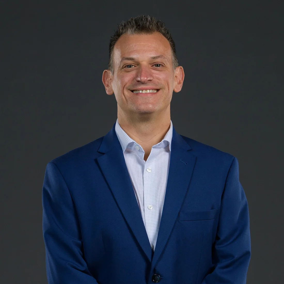 Portrait of Greg Gania in a royal-blue suit jacket